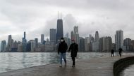 FILE PHOTO: People wearing protective face masks walk, as the global outbreak of the coronavirus disease (COVID-19) continues, along the shores of Lake Michigan in Chicago, Illinois, U.S., December 6, 2020. REUTERS/Shannon Stapleton/File Photo
