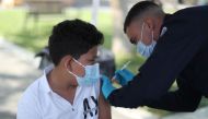 Alessandro Roque, 12, receives a coronavirus disease (COVID-19) vaccination as part of a vaccine drive by the Fernandeno Tataviam Band of Mission Indians in Arleta, Los Angeles, California, U.S., August 23, 2021. REUTERS/Lucy Nicholson

