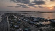 Houses, businesses and beaches are seen damaged at the entrance to Grand Isle at sunset after the town and barrier island was left devastated by Hurricane Ida as seen in this aerial image over Louisiana, U.S., September 2, 2021. Picture taken with a drone