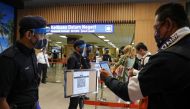 A tourist scans a QR code to check in upon arriving at the airport as Langkawi reopens to domestic tourists, amid the coronavirus disease (COVID-19) pandemic in Malaysia September 16, 2021. REUTERS/Lim Huey Teng