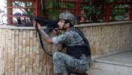An army soldier takes position after gunfire erupted at a site near a protest that was getting underway against Judge Tarek Bitar, who is investigating last year's port explosion, in Beirut, Lebanon October 14, 2021. Reuters/Mohamed Azakir