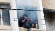 Civil defence members attempt to put out a fire inside a building after gunfire erupted in Beirut, Lebanon October 14, 2021. (REUTERS/Aziz Taher)
