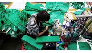 A woman works on tracksuits inspired by Netflix series 