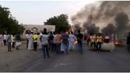 People gather around as smoke and fire are seen on the streets of Khartoum, Sudan, amid reports of a coup, October 25, 2021, in this still image from video obtained via social media. RASD SUDAN NETWORK via REUTERS