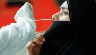 A health worker in personal protective equipment (PPE) collects a swab sample from a woman during a rapid antigen testing campaign for the coronavirus disease (COVID-19), at a railway station platform in Mumbai, India, August 27, 2021. REUTERS/Francis Mas
