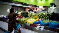 FILE PHOTO: Two grandmothers with their granddaughter trade vegetables at a market on the outskirts of Shanghai, China June 3, 2021. REUTERS/Aly Song