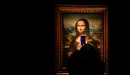 A visitor takes a photo of a copy of the Leonardo da Vinci's Mona Lisa, which will go up for auction on November 9, at the Artcurial auction house in Paris, France, November 5, 2021. REUTERS/Noemie Olive