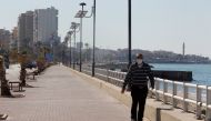 A man wearing a face mask walks along a corniche, amid the spread of the coronavirus disease (COVID-19), in Sidon, Lebanon February 9, 2021. REUTERS/Aziz Taher

