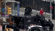 An armed man speaks with members of the NYPD outside the UNited Nations Headquarters in New York City, U.S., December 2, 2021. REUTERS/Carlo Allegri
