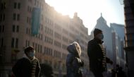 People wearing protective face masks walk on a street, following new cases of the coronavirus disease (COVID-19), in Shanghai, China, December 30, 2021. REUTERS/Aly Song