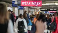 Travelers are seen under a PSA advising mask wearing in a concourse during the holiday season as the coronavirus Omicron variant threatens to increase case numbers at Hartsfield-Jackson Atlanta International Airport in Atlanta, Georgia, U.S. December 22, 2021. REUTERS/Elijah Nouvelage


