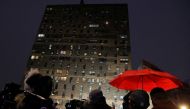 People stand outside an apartment building where a fire occurred in the Bronx borough of New York City, U.S., January 9, 2022. REUTERS/Andrew Kelly