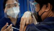 A health worker inoculates a colleague with a booster shot of COVID-19 Pfizer vaccine as the government begins to provide them to front-liners, at the National Kidney and Transplant Institute in Quezon City, Metro Manila, Philippines, November 17, 2021. REUTERS/Eloisa Lopez/File Photo