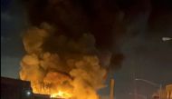 A thick plume of smoke rises over a burning building which is seen through the windshield of a vehicle, in Passaic, New Jersey, U.S., January 14, 2022 in this screen grab obtained from a video on social media. Maria Alberto/via REUTERS 
