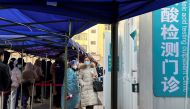 People line up to take nucleic acid tests at a testing site outside a hospital, following a new confirmed case of the coronavirus disease (COVID-19), in Beijing, China January 16, 2022. REUTERS/Yew Lun Tian