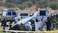 An emergency crew members, including a forensic worker and a firefighter, work next to a damaged vehicle at the site of an accident after a van overturned and flipped into a ditch on a highway in central Mexico, near the city of Lagos de Moreno, Mexico January 29, 2022. REUTERS/Liberto Urena