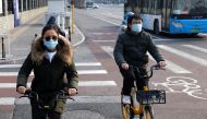 People wearing protective masks ride bicycles, as the coronavirus disease (COVID-19) pandemic continues, in Beijing, China January 30, 2022. REUTERS/Tyrone Siu