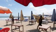 Workers pack up the parasols to close the beach as Indonesia imposes emergency measures, tightening restrictions in Java and Bali as coronavirus disease (COVID-19) cases surge, in Seminyak, Bali, Indonesia, July 3, 2021. REUTERS/Nyimas Laula/File Photo