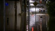 People observe a flooded street after heavy rain in Caieiras, Brazil January 30, 2022. REUTERS/Carla Carniel