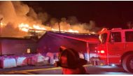 A firefighter walks past a fire engine as Weaver Fertilizer Plant burns on Cherry Street in Winston-Salem, North Carolina, U.S., January 31, 2022, in this screen grab taken from a video recorded on January 31, 2022. City of Winston-Salem via Facebook/Handout via Reuters 
