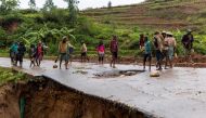 Locals stand on a damaged road following a landslide, as Cyclone Batsirai hits Madagascar, in Haute Matsiatra region, Madagascar, February 6, 2022. REUTERS/Alkis Konstantinidis