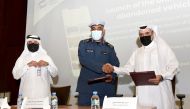 Chairman of Joint Committee for Removing Abandoned Vehicles Major General Ali Salman Al Mohannadi and Executive Director of Mzad Qatar Fahad Abdullah Al Nuaimi exchanging documents after signing the agreement.