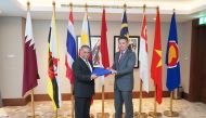 Indonesian Ambassador Ridwan Hassan handing over the ASEAN flag to Malaysian Ambassador Zamshari Shaharan as the new Chairman of ASEAN Committee in Doha.