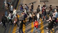 People wearing face masks cross a street following the coronavirus disease (COVID-19) outbreak, in Hong Kong, China February 15, 2022. REUTERS/Lam Yik/File Photo