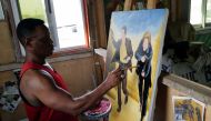 Ghanaian movie poster artist Daniel Anum Jasper, 54, works on a commissioned movie poster for a foreign client at his worksop in the Teshie area of Accra, Ghana February 11, 2022. REUTERS/Francis Kokoroko