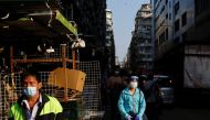 People wearing face masks walk on the street, following the coronavirus disease (COVID-19) outbreak, in Hong Kong, China March 4, 2022. REUTERS/Tyrone Siu