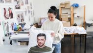 A woman holds a pillow cover with a portrait depicting Ukrainian President Volodymyr Zelenskiy, in Ceska Lipa, Czech Republic, March 17, 2022. Picture taken March 17, 2022. REUTERS/Eva Korinkova
