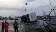 People look at an overturned truck in a parking lot after a tornado in a widespread storm system touched down in Round Rock, Texas, U.S., March 21, 2022. REUTERS/Tamir Kalifa