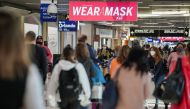Travelers are seen under a PSA advising mask wearing in a concourse during the holiday season as the coronavirus Omicron variant threatens to increase case numbers at Hartsfield-Jackson Atlanta International Airport in Atlanta, Georgia, U.S. December 22, 2021. REUTERS/Elijah Nouvelage

