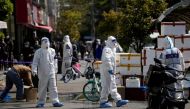Police and security members in protective suits stand outside cordoned off food stores following the coronavirus disease (COVID-19) outbreak in Shanghai, China March 29, 2022. REUTERS/Aly Song/File Photo