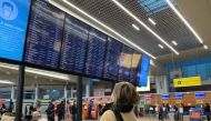 A passenger looks at a departures board at Sheremetyevo airport, after Russia closed its airspace to airlines from 36 countries in response to Ukraine-related sanctions targeting its aviation sector, in Moscow, Russia February 28, 2022.  REUTERS/Stringer/File Photo