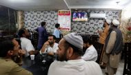 People watch the speech of Pakistani Prime Minister Imran Khan on a television screen, at a cafe in Islamabad, Pakistan, April 8, 2022. (Reuters/Akhtar Soomro)