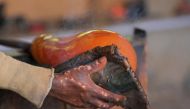 The scarred hand of Ghanaian glassblower Michael Tetteh, 44, is pictured as he shapes molten glass at his glassware manufacturing workshop in Krobo Odumase, Ghana March 15, 2022. Picture taken March 15, 2022. REUTERS/Francis Kokoroko
