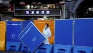 A worker in a protective suit keeps watch next to barricades set around a sealed-off area, during a lockdown to curb the spread of the coronavirus disease (COVID-19) in Shanghai, China April 11, 2022. REUTERS/Aly Song

