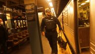A police officer checks Manhattan subways after a shooting at a subway station in the Brooklyn borough of New York City, New York, U.S., April 12, 2022. REUTERS/Jeenah Moon
 