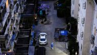 A worker in protective suit speaks through a megaphone as he directs residents of the buildings to go for pick up food inside an area under lockdown, in Shanghai, China, April 17, 2022. Reuters/Aly Song