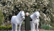 British Queen Elizabeth II holds her Fell ponies, Bybeck Nightingale (right) and Bybeck Katie in this handout picture released April 20, 2022 by The Royal Windsor Horse Show to mark the occasion of her 96th birthday. henrydallalphotography.com/PA Wire/Handout via Reuters 