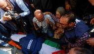 Mourners, including journalists, react next to the body of Al Jazeera reporter Shireen Abu Akleh, May 11, 2022. Reuters/Mohamad Torokman