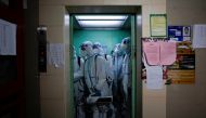 Workers in protective suits take an elevator as they disinfect a residential area during lockdown, amid the coronavirus disease (COVID-19) pandemic, in Shanghai, China, May 18, 2022. REUTERS/Aly Song