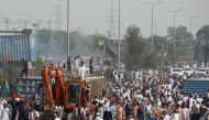 Supporters of the Pakistan Tehreek-e-Insaf (PTI) political party sit atop of a crane after they removed the shipping containers, used to block the roads to prevent them from attending the protest march planned by ousted Prime Minister Imran Khan in Islamabad, in Rawalpindi, Pakistan May 25, 2022. REUTERS/Akhtar Soomro
