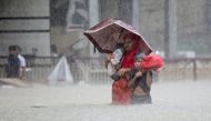 People wade through the water as they look for shelter during a flood, amidst heavy rains that caused widespread flooding in the northeastern part of the country, in Sylhet, Bangladesh, June 18, 2022. Reuters/Abdul Goni 