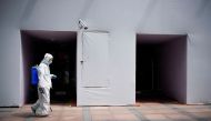 A worker in a protective suit disinfects following the coronavirus disease (COVID-19) outbreak, under a surveillance camera on street in Shanghai, China July 1, 2022. REUTERS/Aly Song



