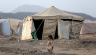 A girl walks past a tent at a camp for internally displaced people in Marib, Yemen, April 5, 2021. (Reuters/Ali Owidha)