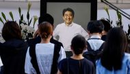 People lay flowers at Zojoji Temple where the vigil and funeral of late former Japanese Prime Minister Shinzo Abe takes place, in Tokyo, Japan, July 11, 2022. (REUTERS/Kim Kyung-Hoon)

