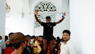 A demonstrator shouts to control the crowd inside President Gotabaya Rajapaksa's house, as demonstrators entered into the building after the president fled, amid the country's economic crisis, in Colombo, Sri Lanka, July 11, 2022. (REUTERS/Dinuka Liyanawatte)
