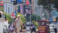 A man wearing a face mask pulls a cart on a street amid a heatwave warning, following the coronavirus disease (COVID-19) outbreak in Shanghai, China July 13, 2022. REUTERS/Aly Song